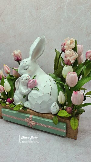 Osterdeko mit Hasenfigur und Tulpen